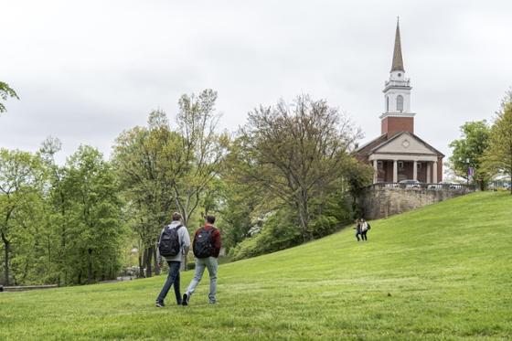 Large green-leafed trees line Chatham University's academic quad in Shadyside while students walk to class. 